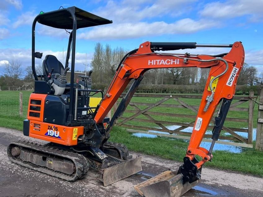 Hitachi ZX19U 1.9-tonne mini digger parked by a field gate